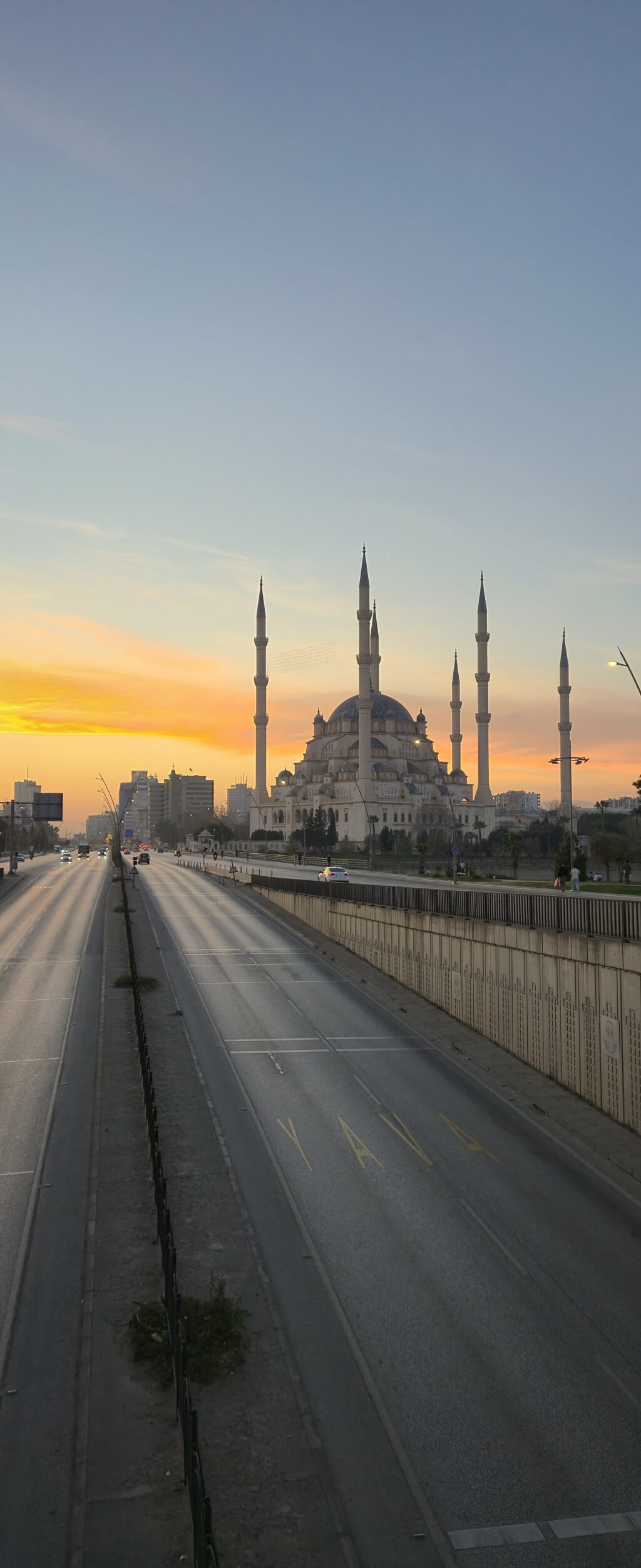 Güneşin batışı sırasında bir cami ve açık bir yol manzarası